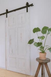 an old door with a plant on a stool at Alfreda in Sokołowsko