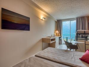 a hotel room with a bed and a desk and a window at Hotel Cristina in Limone sul Garda