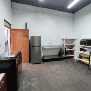 eine Küche mit einem Kühlschrank und einem Tisch darin in der Unterkunft Casona en barrio Italia in Santiago