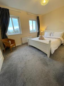 1 dormitorio con 1 cama blanca y 1 silla en Glor Na Farraige 15 en Knights Town