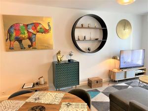 uma sala de estar com uma pintura de elefante na parede em Bel appartement 3 étoiles WIFI Netflix à 200m plage, au centre de TREGASTEL - Ref 702 em Trégastel