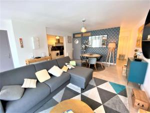 uma sala de estar com um sofá azul e uma cozinha em Bel appartement 3 étoiles WIFI Netflix à 200m plage, au centre de TREGASTEL - Ref 702 em Trégastel