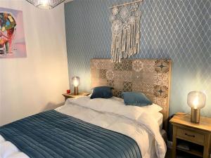 um quarto com uma cama grande e um cobertor azul em Bel appartement 3 étoiles WIFI Netflix à 200m plage, au centre de TREGASTEL - Ref 702 em Trégastel