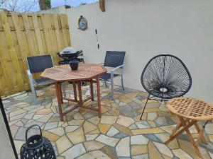 een patio met een tafel en stoelen en een hek bij Studio avec terrasse in Brest