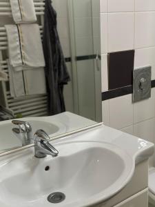 La salle de bains est pourvue d'un lavabo blanc et d'un miroir. dans l'établissement cosy loft in town house, à Paris