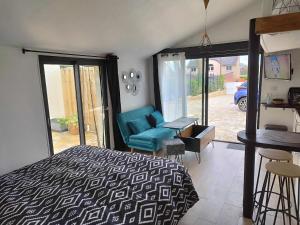 a bedroom with a bed and a chair and a table at Studio avec terrasse in Brest