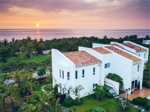 an aerial view of a white house in front of the ocean at Bay Forest Boutique B&B in Hengchun