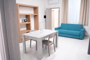 un soggiorno con un tavolo e un divano blu di San Cataldo Hotel a Faggiano