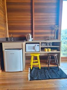 a kitchen with a counter with a microwave and two stools at Cabana Deck 2 in Orleans