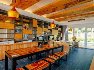 a kitchen with a large wooden table and chairs at Bay Forest Boutique B&B in Hengchun