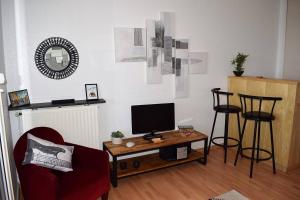 ein Wohnzimmer mit einem TV und einem Tisch mit Stühlen in der Unterkunft Appartement VUE MER EXCEPTIONNELLE avec WIFI à TREGASTEL - Réf 729 in Trégastel