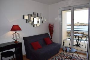 ein Wohnzimmer mit einem blauen Sofa und einem Tisch in der Unterkunft Appartement VUE MER EXCEPTIONNELLE avec WIFI à TREGASTEL - Réf 729 in Trégastel