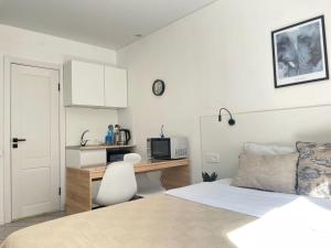 a bedroom with a bed and a desk with a microwave at Seven City Apartments in Semey