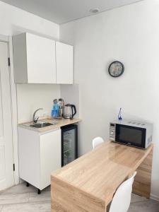 a kitchen with a counter top and a microwave at Seven City Apartments in Semey