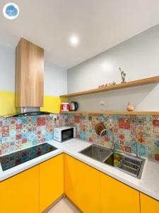 - une cuisine avec des placards jaunes et un évier dans l'établissement It Dust Homestay 5 - The Sunny Apartment, à Gia Lâm Pho
