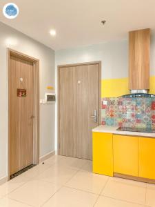 une cuisine avec un comptoir jaune et une porte dans l'établissement It Dust Homestay 5 - The Sunny Apartment, à Gia Lâm Pho