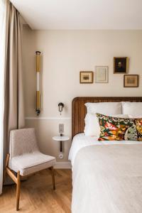 a bedroom with a bed and a chair at Hôtel Chamar in Paris