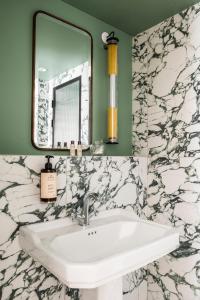 uma casa de banho com um lavatório e um espelho em Hôtel Chamar em Paris