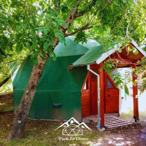 una casa verde y roja con un árbol en Puelo EnDomos en Lago Puelo