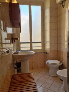 bagno con lavandino, servizi igienici e finestra di Reyes Suite a Roma