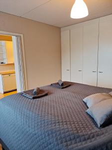 a bedroom with a bed with two slippers on it at Mesikämmen - Free parking & WiFi - Next to the forest - Rating 9,4 in Jyväskylä