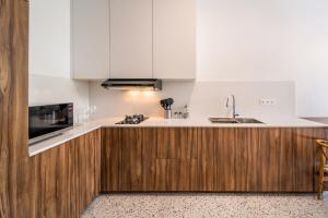 a kitchen with white cabinets and a sink at Sunny Village Berawa in Canggu