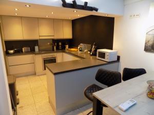 a kitchen with a counter and chairs and a microwave at Vakantiewoning Hartje Maaseik in Maaseik