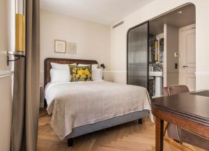 a bedroom with a bed and a dining room at Hôtel Chamar in Paris +41 photos