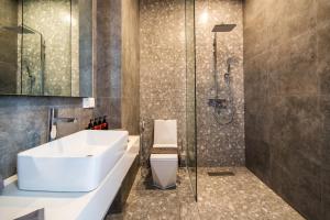 a bathroom with a white sink and a shower at Sunny Village Berawa in Canggu