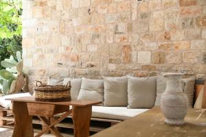 B&B Masseria Piccola في تْشيستيرنِنو: غرفة معيشة مع أريكة بيضاء وجدار من الطوب