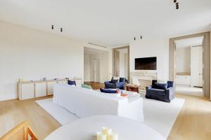 ein Wohnzimmer mit einem weißen Sofa und Stühlen in der Unterkunft Pick A Flat's Apartment in Invalides - Rue de Constantine in Paris
