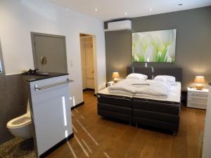 a bedroom with a bed and a toilet in it at Vakantiewoning Hartje Maaseik in Maaseik +3 photos