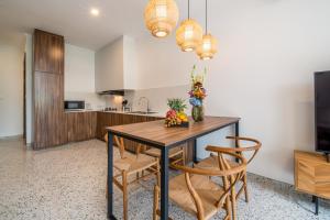 a kitchen with a dining room table and chairs at Sunny Village Berawa in Canggu