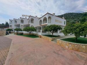 a large white building with trees in front of it at Aretousa in Tolo