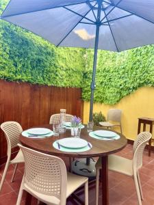 uma mesa com cadeiras e um guarda-sol num pátio em 2Room Cozy Apartment Center Caparica em Costa da Caparica