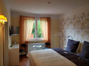 a bedroom with a bed and a window at Privatpension Waldbröl in Waldbröl