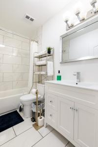 a white bathroom with a sink and a toilet at Luxueux condo au cœur de Québec! in Quebec City