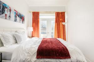 a bedroom with a bed with a red blanket on it at Luxueux condo au cœur de Québec! in Quebec City