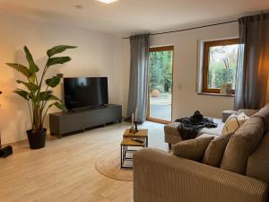 un soggiorno con divano e TV a schermo piatto di Casa Schneck a Longkamp