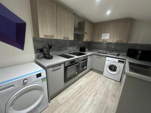a kitchen with a washing machine and a washer at Inviting Studio Flat at Lewisham Way SE14 London in London
