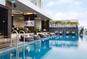 a hotel swimming pool with chairs and a building at Liberty Central Saigon Riverside Hotel in Ho Chi Minh City