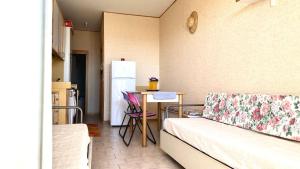 Zimmer mit einem Sofa und einem Tisch mit einem Kühlschrank in der Unterkunft SE068 - Senigallia, bilocale sul mare al residence Piramidi in Scapezzano