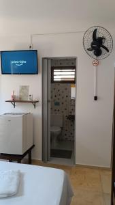 a bedroom with a door to a bathroom with a toilet at Suítes Preguiça in Canoa Quebrada