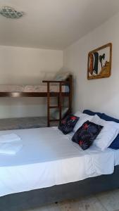 a bed in a room with two pillows on it at Suítes Preguiça in Canoa Quebrada