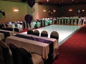 un salón de banquetes con mesas y sillas blancas y verdes en OYO Dunmar House Hotel, en Alloa