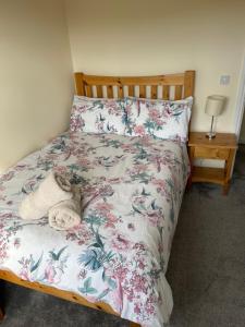 a bedroom with a bed with a floral bedspread at Glor Na Farraige 15 in Knights Town