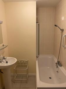 uma casa de banho com uma banheira, um lavatório e um chuveiro em Glor Na Farraige 15 em Knights Town