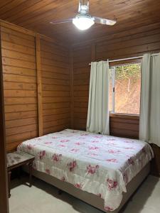 ドミンゴス・マルチンスにあるChalé Essência do Valeの窓のある部屋にベッドのある寝室