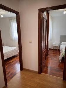 Une porte s'ouvre sur une chambre dotée d'un lit. dans l'établissement PISO OROSO NO CAMIÑO, à Sigüeiro