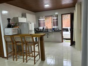 ドミンゴス・マルチンスにあるChalé Essência do Valeのキッチン(テーブル、椅子、電子レンジ付)